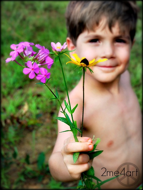 my son is about five in this image. we are at the lake & he is in his bathing suit.  I was photographing flowers & i heard, "here mom, i picked these for you…i left the roots on so you can plant them in your garden"  A beautiful moment captured here.